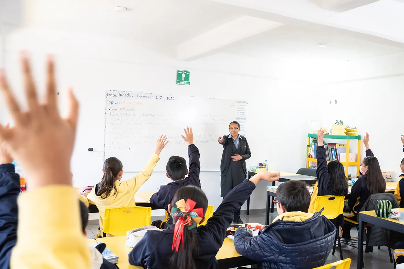 Alumnos de primaria levantando la mano en clase